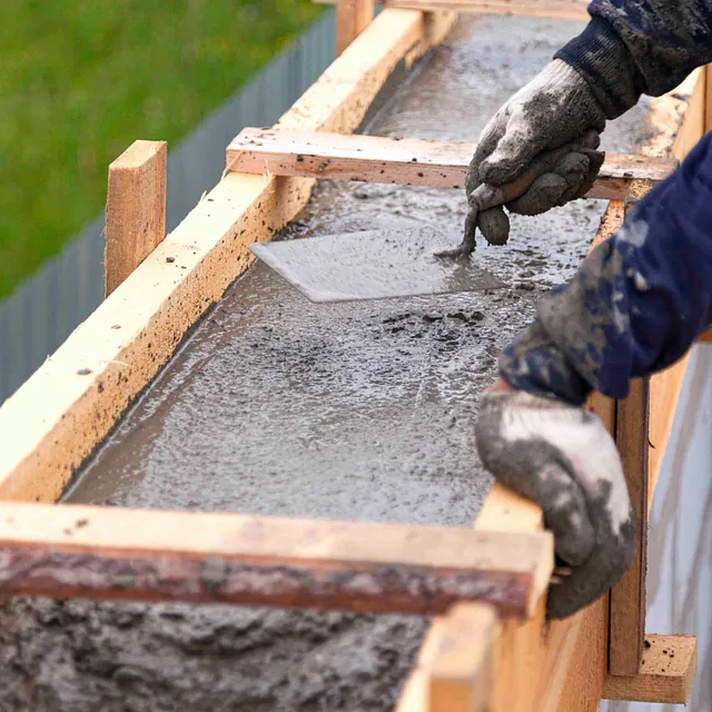 Ein Mann bearbeitet flüssigen Beton