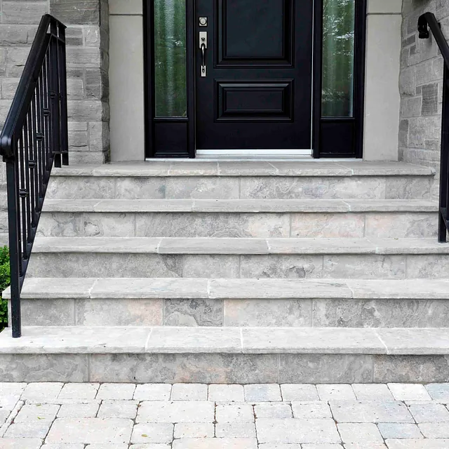 Eine helle Steintreppe vor einem Haus