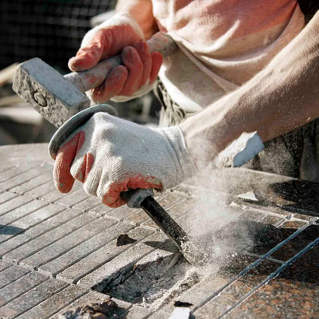 Ein Mann meiselt Beton